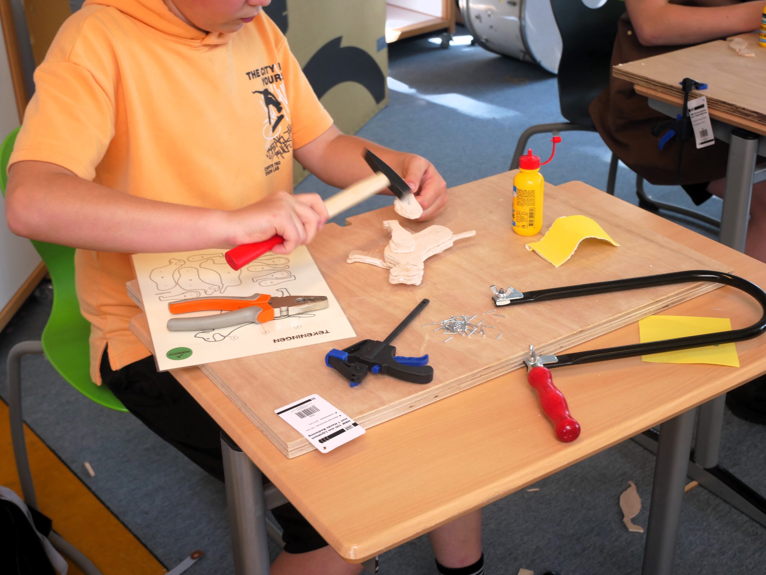 Wooditz workshop - leerling spijkert poten vast